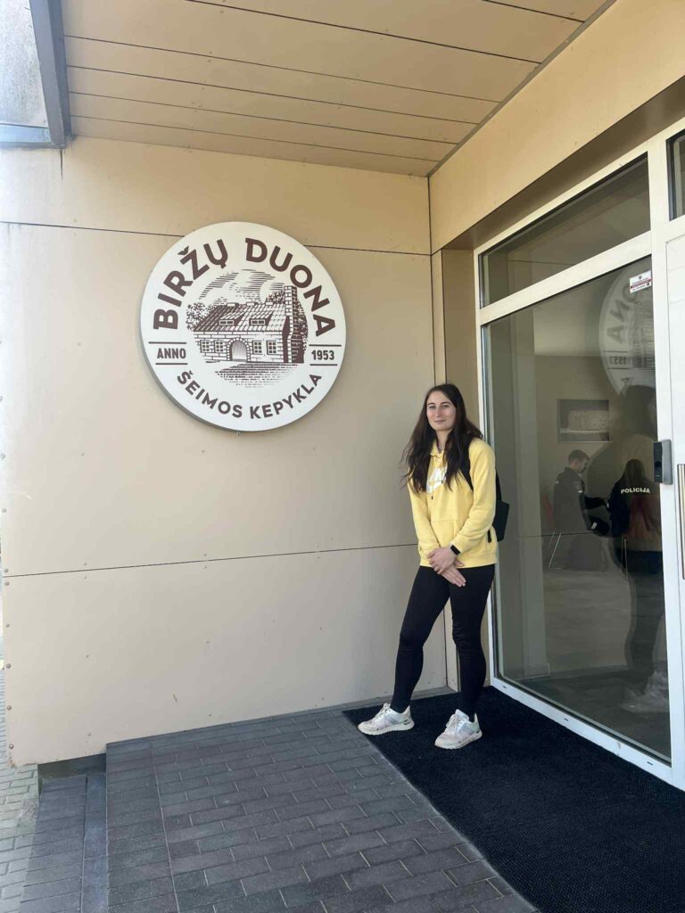 Dovilė stovi prie savo darbovietės "Biržų duona" durų.
