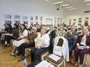 Konferencijos Zarasuose dalyviai sėdi salėje ir klausosi pranešimų. Pirmose eilėse ir salės gilumoje matyti renginyje dalyvaujantys specialistai bei institucijų atstovai.